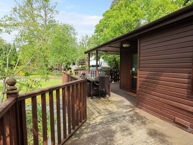 An outdoor deck area with a table and chairs at Costapacket in Grasmere 12, White Cross Bay near Windermere