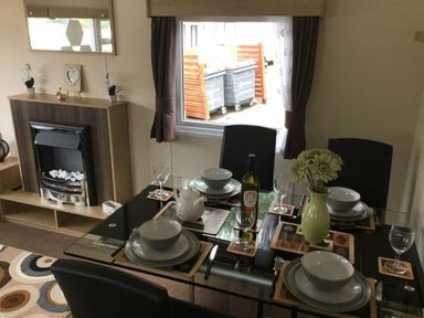 a dining area with a glass table set for four at Waterside, Paignton - Holiday Accommodation 10036, Paignton