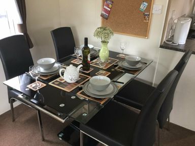 a dining table set with bowls and cutlery at Waterside, Paignton - Holiday Accommodation 10036, Paignton