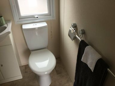 a bathroom with a toilet and towel rack at Waterside, Paignton - Holiday Accommodation 10036, Paignton