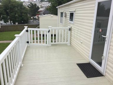 a deck area with white railings and a door at Waterside, Paignton - Holiday Accommodation 10036, Paignton