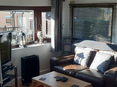 a living room featuring a brown sofa, coffee table, and window with blinds at Hafan y Mor Haven - Holiday Accommodation 10104, Pwllheli