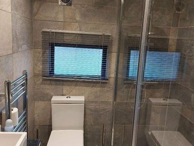 a bathroom with a toilet and a shower enclosure at Hafan y Mor Haven - Holiday Accommodation 10104 Pwllheli