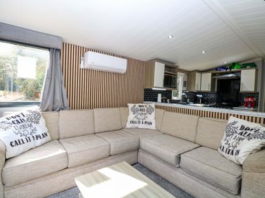 A living room with a sofa and coffee table at Wild Duck Holiday Park in Belton, Norfolk