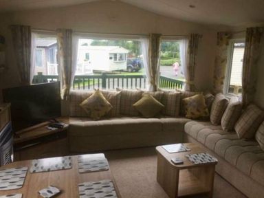 a living room with a large sofa and a television at Hafan y Mor Haven - Holiday Accommodation 11370 Pwllheli