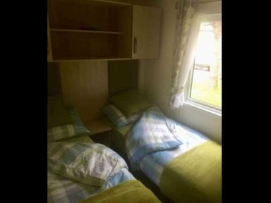 a bedroom with two beds and a window at Hafan y Mor Haven - Holiday Accommodation 11370 Pwllheli