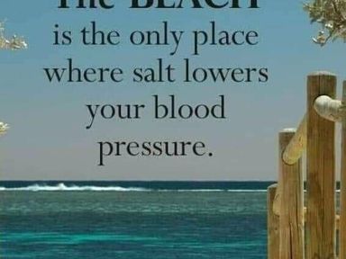 a sign about the beach and health with water in the background at Hafan y Mor Haven - Holiday Accommodation 11370, Pwllheli