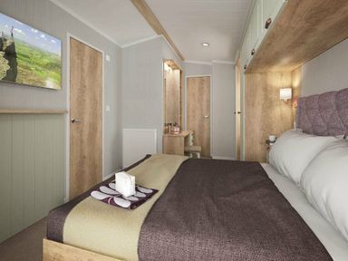 a bedroom with a bed, a television, and a dressing area at Perran Sands - Holiday Accommodation 12174 Perranporth