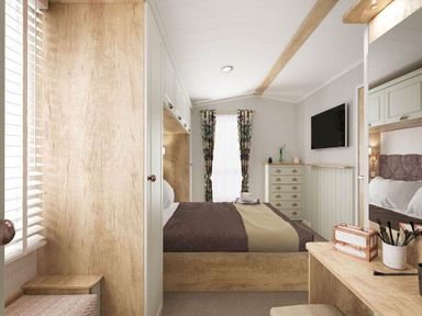 a bedroom with a double bed, dresser, and television at Perran Sands - Holiday Accommodation 12174 Perranporth