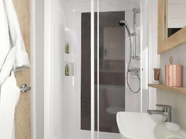 a shower area with glass door, shelves, towel, and toiletries at Perran Sands - Holiday Accommodation 12174, Perranporth