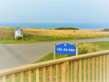 a sign for Chy-An-Mor near a coast with grass and ocean view at Perran Sands - Holiday Accommodation 12174 Perranporth