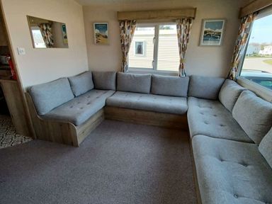 a seating area with a gray sectional sofa at Hafan y Mor Haven - Holiday Accommodation 12637, Pwllheli