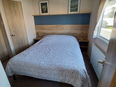 a bedroom with a double bed and bedside tables at Hafan y Mor Haven - Holiday Accommodation 12637 in Pwllheli
