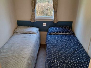 a bedroom with two single beds and a window at Hafan y Mor Haven - Holiday Accommodation 12637 Pwllheli