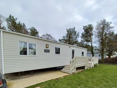 a holiday home with a porch and steps surrounded by grass at Hafan y Mor Haven - Holiday Accommodation 12637 Pwllheli
