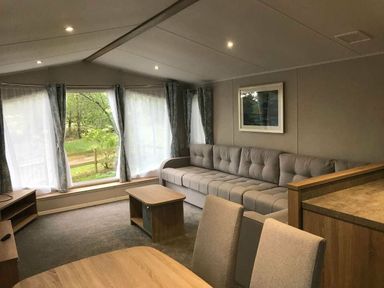 a living room with a sectional sofa and a coffee table at Kelling Heath Holiday Park - Holiday Accommodation 13133 in Holt