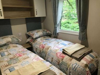 a bedroom with two single beds and a window at Kelling Heath Holiday Park - Holiday Accommodation 13133 in Holt