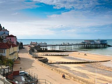 a view of a pier extending into the sea with a sandy beach at Kelling Heath Holiday Park - Holiday Accommodation 13133, Holt