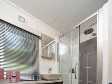 a bathroom with a shower, sink, mirror, and window at Ocean Edge Leisure Park - Holiday Accommodation 1317, Heysham