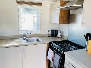 a kitchen with a sink, stove, and cabinetry at Butlins Minehead - Holiday Accommodation 13288, Minehead