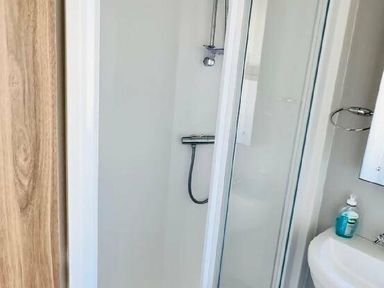 a shower area with a glass door and showerhead at Butlins Minehead - Holiday Accommodation 13288, Minehead