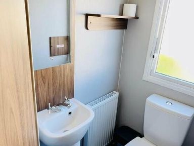 a bathroom with a sink, toilet, and shelf at Butlins Minehead - Holiday Accommodation 13288, Minehead