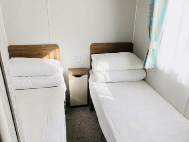 a bedroom with two single beds and a bedside table at Butlins Minehead - Holiday Accommodation 13288 in Minehead