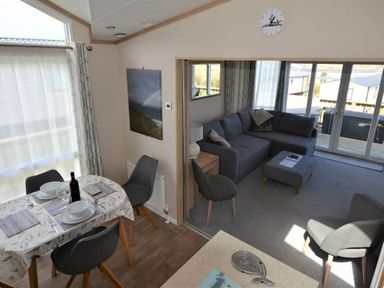 a dining area with a table and chairs overlooking a living room at Perran Sands - Holiday Accommodation 15012, Perranporth