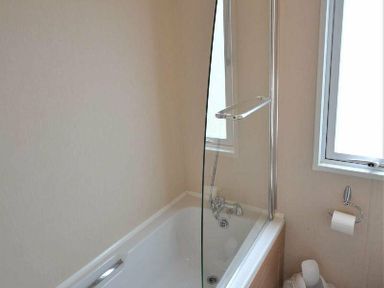 a bathroom featuring a bathtub with a glass shower screen at Perran Sands - Holiday Accommodation 15012 in Perranporth