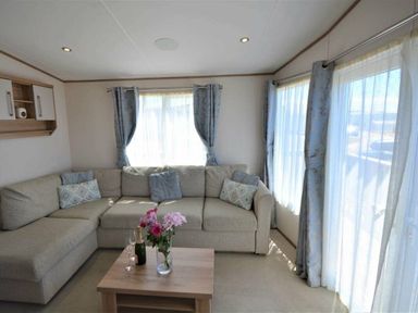 a living room with a sectional sofa and a coffee table at Perran Sands - Holiday Accommodation 15598 in Perranporth