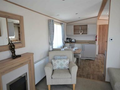 a living room with a seating area, kitchen, and dining space at Perran Sands - Holiday Accommodation 15598 Perranporth