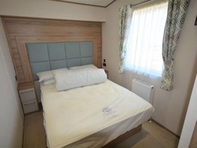 a bedroom with a bed, window, and radiator at Perran Sands - Holiday Accommodation 15598 in Perranporth