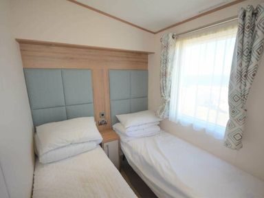 a bedroom with two twin beds and a window at Perran Sands - Holiday Accommodation 15598, Perranporth