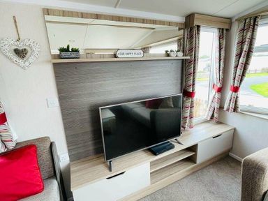 a living room with a television on a cabinet and curtains at Unity Holiday Resort - Holiday Accommodation 15970, Brean Sands