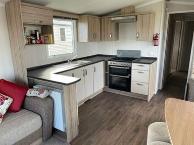 a kitchen with cabinets, a stove, and a sink at Unity Holiday Resort - Holiday Accommodation 15970, Brean Sands