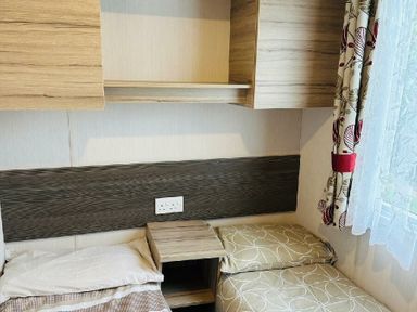 a bedroom with wooden shelves and a bed with cushions at Unity Holiday Resort - Holiday Accommodation 15970, Brean Sands