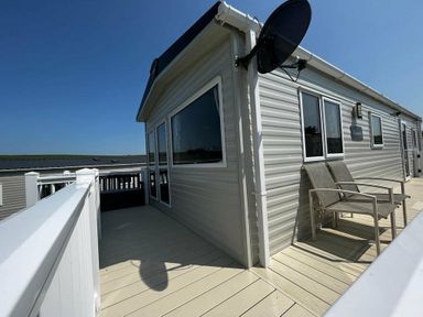 a modular building with a terrace and outdoor seating at Newquay Bay Resort - Holiday Accommodation 15978 in Newquay