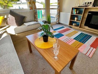 a living room with a coffee table, plant, and colorful rug at Newquay Bay Resort - Holiday Accommodation 15978, Newquay