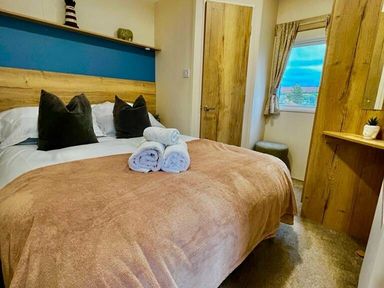 a bedroom with a double bed and towels on the bed at Newquay Bay Resort - Holiday Accommodation 15978 in Newquay