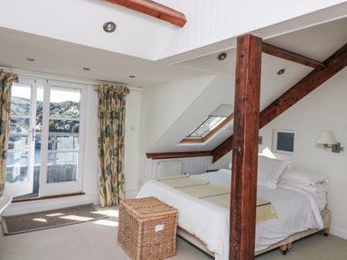 A bedroom with a bed and balcony window at Fastnet at Nonsuch House in Kingswear, Devon