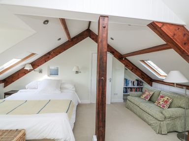 A bedroom with a bed and a sofa at Fastnet at Nonsuch House Kingswear, Devon