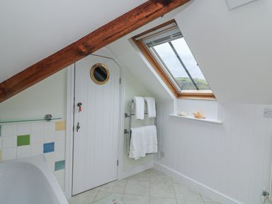 A bathroom with a bathtub and towels at Fastnet at Nonsuch House Kingswear, Devon