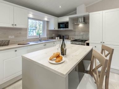 a kitchen with a table featuring croissants and drinks at Kelling Heath Holiday Park - Holiday Accommodation 16221, Holt