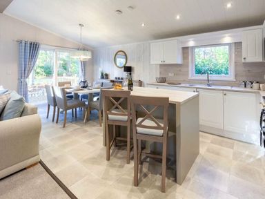 a kitchen and dining area with an island and table at Kelling Heath Holiday Park - Holiday Accommodation 16221 in Holt
