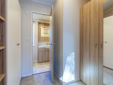 a hallway with doors leading to rooms and a vanity area at Kelling Heath Holiday Park - Holiday Accommodation 16221, Holt