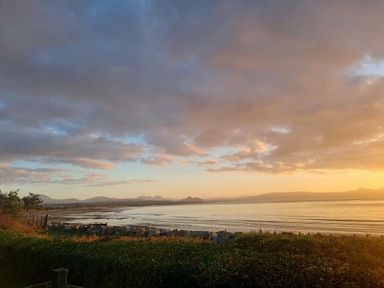 a coastal view with clouds and sunset at Hafan y Mor Haven - Holiday Accommodation 16251 Pwllheli