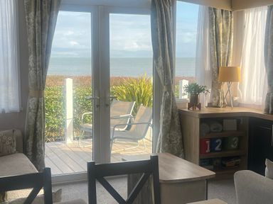 A living room with a view of the sea at Hafan y Mor Haven - Holiday Accommodation 16251 Pwllheli