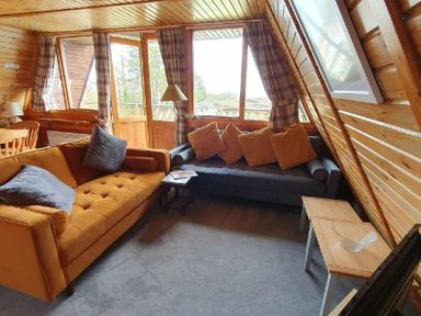 a living room with two sofas, a coffee table, and large windows at Hafan y Mor Haven - Holiday Accommodation 16279 in Pwllheli