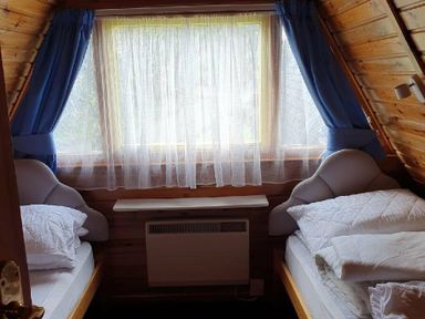 a bedroom with two beds and curtains at Hafan y Mor Haven - Holiday Accommodation 16279 in Pwllheli
