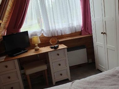 a bedroom with a desk, television, lamp, and wardrobe at Hafan y Mor Haven - Holiday Accommodation 16279, Pwllheli